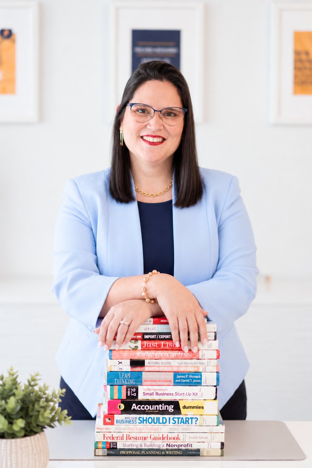 Sylvana Nogueira en su despacho, con una pila de libros de contabilidad y negocios